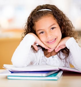 Cute school girl doing her homework and looking happy-1