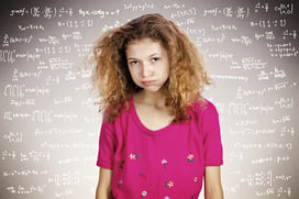 Closeup portrait annoyed, stressed, tired, young student standing in front of blackboard, fed up of studying, isolated chalkboard background filled with math, physics formulas. Face expression emotion